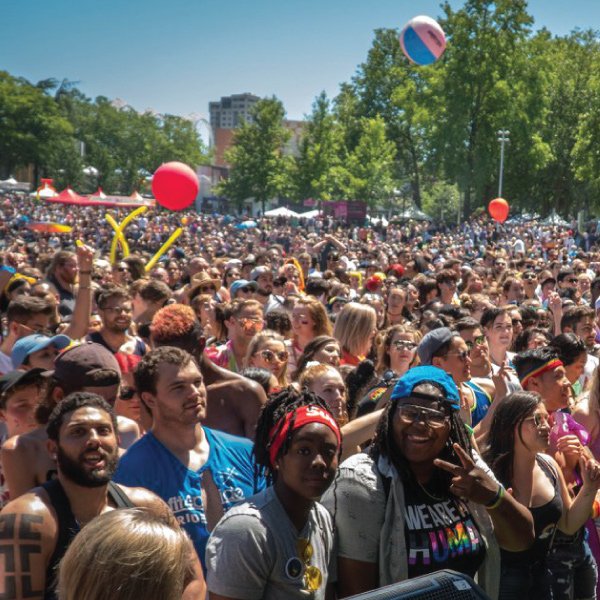 Large diverse crowd celebrating outdoors.